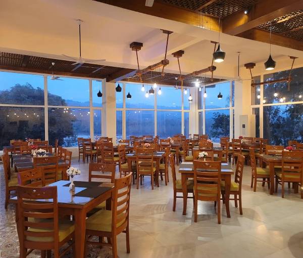 Riverside dining setup at La Perle River Resort, Jim Corbett